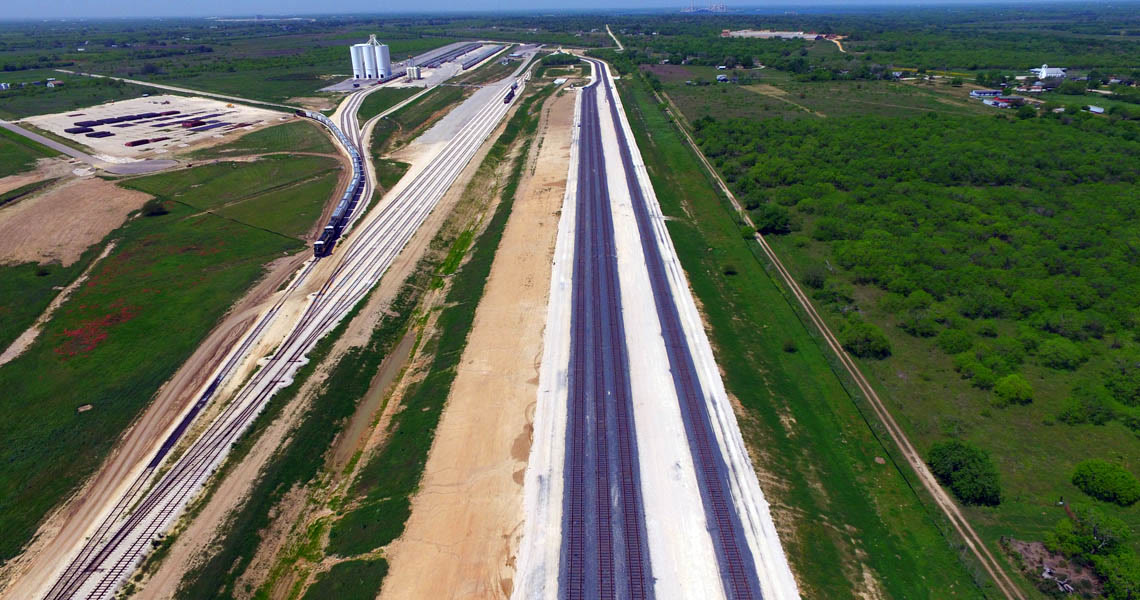 Aerial view of the 8,000-foot unit-train tracks running straight across the park with a train on the far track